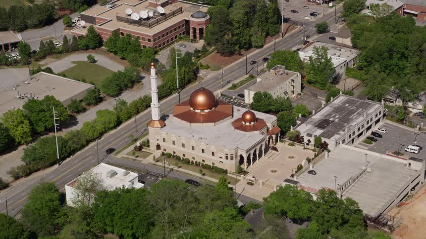 Aerial footage of Al-Farooq Masjid of Atlanta a beautiful mosque with copper domes and a white minaret tower located in Atlanta Georgia on a sunny day in spring or summer