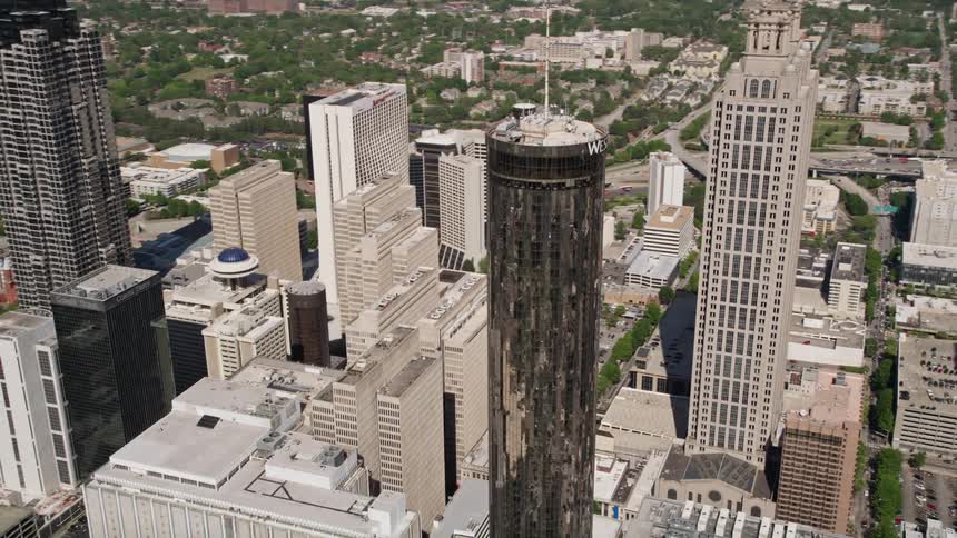 An aerial video orbits the Westin Peachtree Plaza Hotel a tall and sleek skyscraper in downtown Atlanta offering stunning views of the metropolis on a sunny day