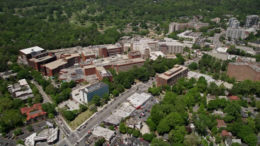 The aerial footage captures Peachtree Road passing by a hospital revealing office buildings and trees in Buckhead Atlanta
