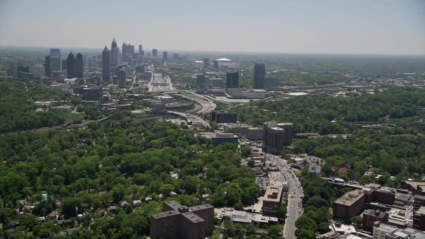 Aerial footage of Peachtree Road approaching the Midtown Atlanta skyline with Buckhead visible shot during the daytime in Georgia