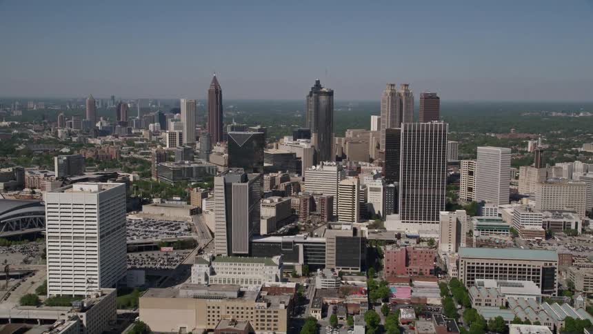 Approaching Downtown Atlantas towering skyscrapers with the Midtown district in the distance during a sunny day