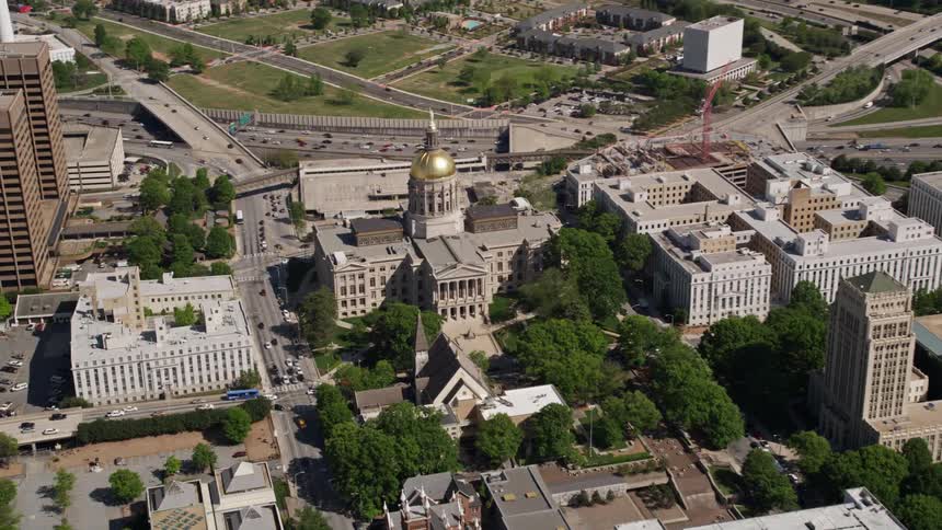 Aerial footage tilting down to birds eye view of the Georgia State Capitol building in downtown Atlanta during daytime