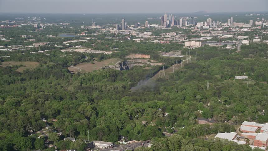 Smoke rises from a house on fire in a wooded neighborhood as seen from above in West Atlanta