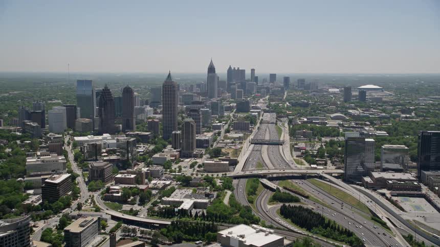 Aerial footage of Downtown Connector as it approaches the tall skyscrapers of Midtown Atlanta Georgia on a sunny day