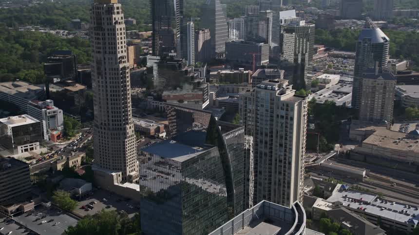 Aerial footage tilting down from skyscrapers to Marsh Mercer building in Buckhead Georgia on a sunny day