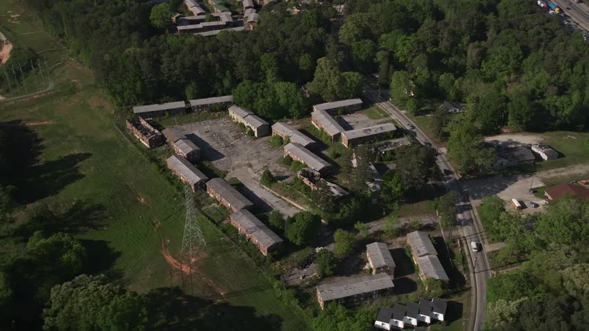 Orbiting aerial footage showcases abandoned warehouses on the outskirts of Atlanta Georgia during a sunny day in summer