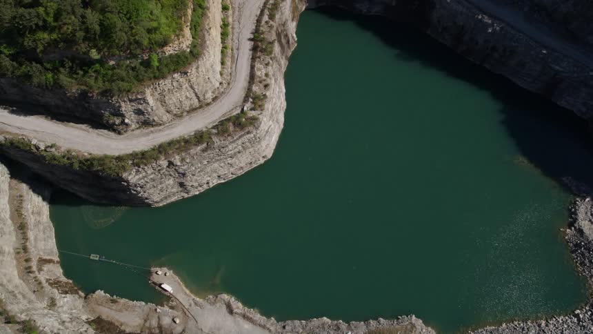 Approaching a sunny quarry in Atlanta Georgia from an aerial view with a tilt down to a birds eye perspective