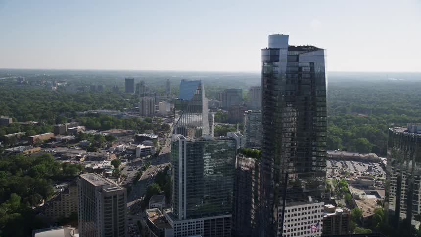 Flying over the 3344 Peachtree skyscraper approaching Terminus Atlanta in Buckhead Georgia during a sunny day