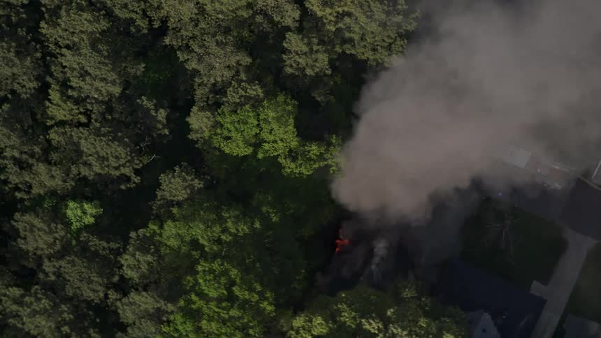 Aerial footage showing smoke rising from a house on fire in West Atlanta Georgia