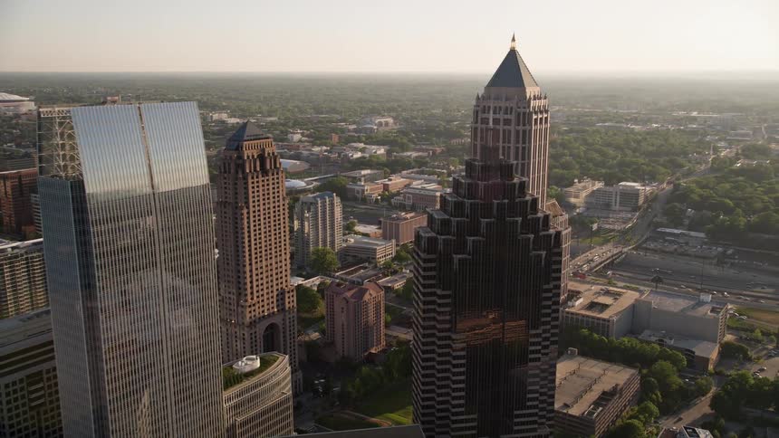 Flying away from Promenade II this aerial footage reveals a stunning cluster of skyscrapers in Midtown Atlanta at sunset