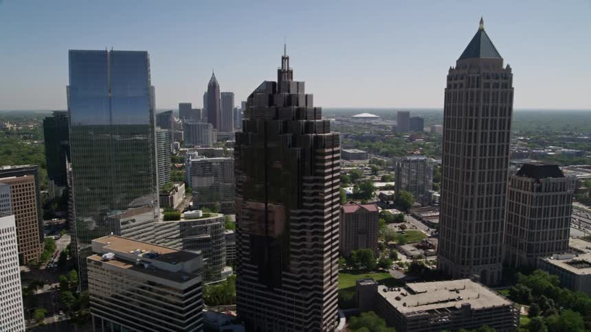 An aerial view of Midtown Atlanta skyscrapers and towers giving way to heavy traffic flowing on the freeway in downtown Georgia