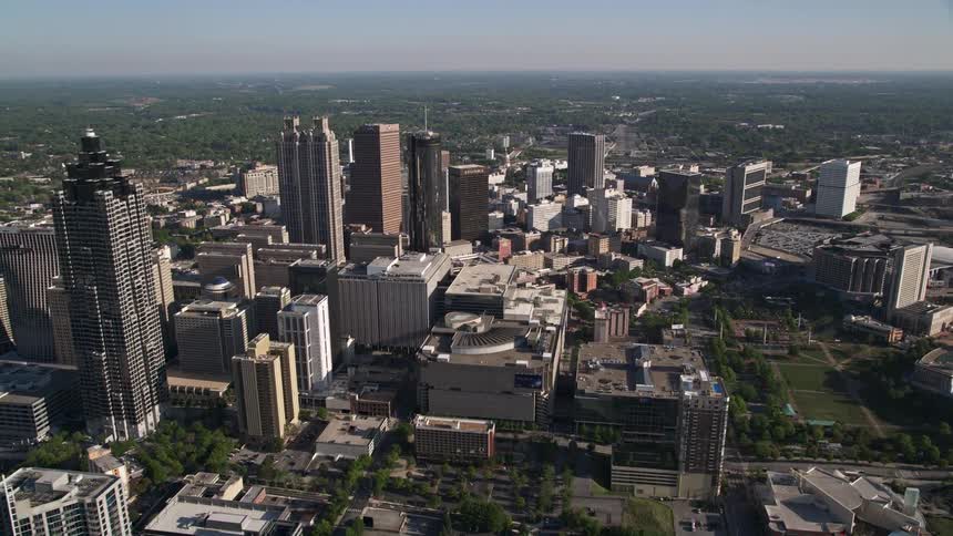 Approaching Downtown Atlantas skyline filled with skyscrapers and office buildings captured via an aerial view during a sunny day