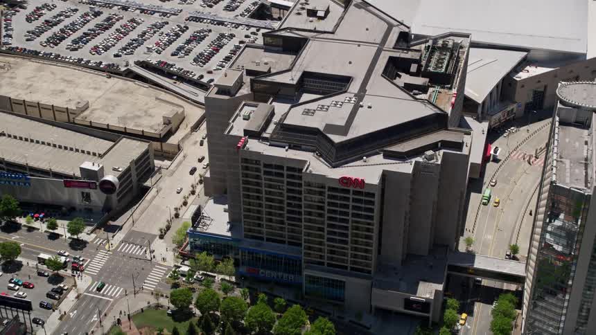 Aerial footage of CNN Center and Omni Hotel orbiting over downtown Atlanta during a sunny day in summer showcasing its industrial and metropolitan areas