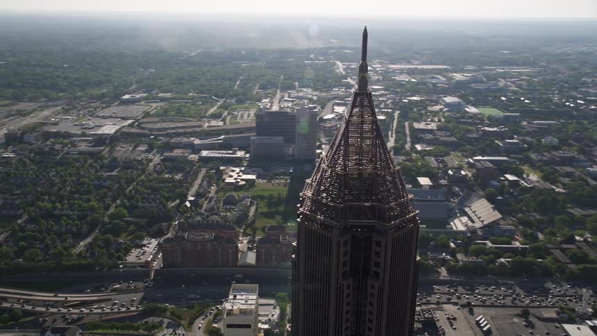 An aerial approach and orbit to the Bank of America Plaza a tall skyscraper with a pyramid structure in Midtown Atlanta Georgia during the daytime
