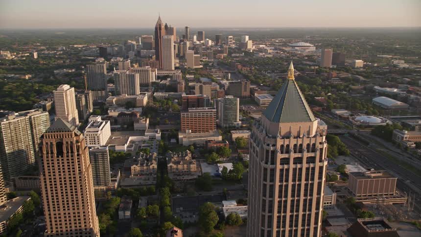Aerial footage orbiting One Atlantic Center revealing the tall skyscrapers of Midtown Atlanta at sunset