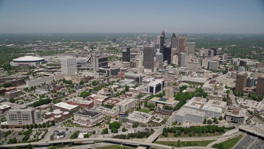 Aerial footage of Downtown Atlantas skyscrapers and freeways during the day with a wide-angle view and light traffic