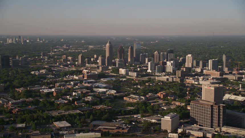 Aerial footage of Midtown Atlantas high-rise buildings during a hazy summer sunset