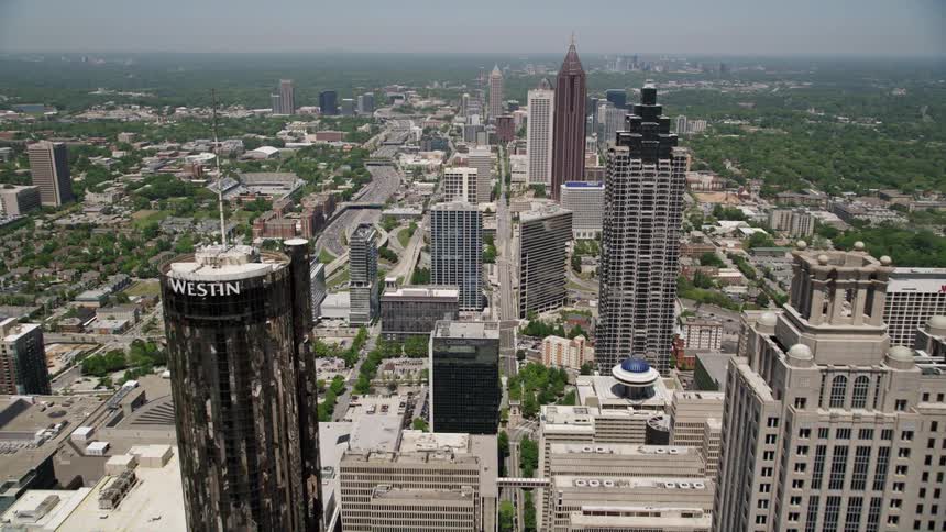 An aerial approach towards the towering skyscrapers in Downtown Atlanta Georgia on a sunny day
