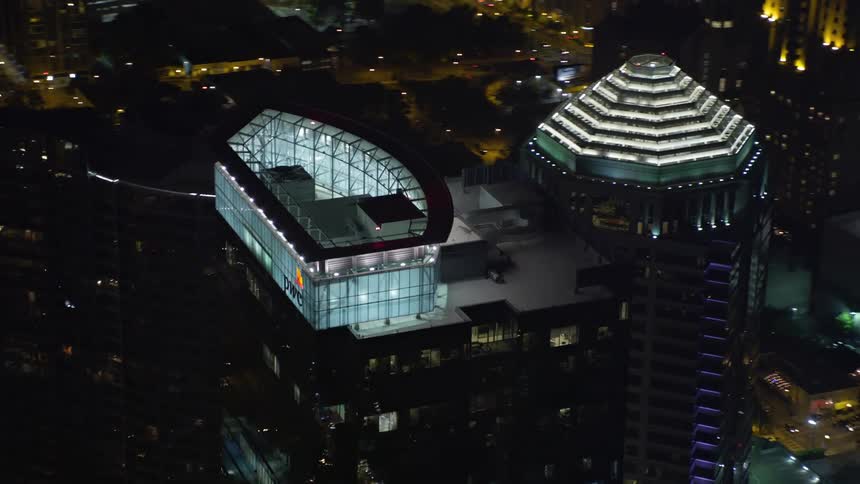 A night-time aerial orbit of the 1075 Peachtree building in Midtown Atlanta showcasing the illuminated skyscrapers and city skyline