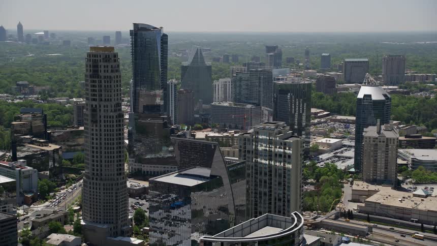 Aerial footage captures the magnificent skyscrapers of Buckhead and tracks to the top of the Marsh Mercer Building rooftop in Atlanta Georgia on a sunny day