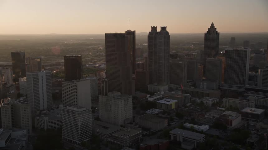 Panning across the Downtown Atlanta skyline this stock footage showcases the hazy sunset illuminating the towering skyscrapers