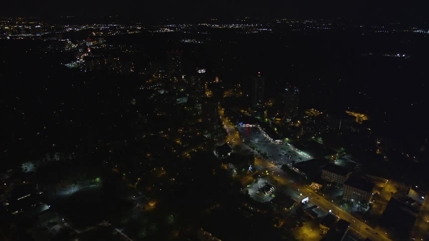 Nighttime aerial footage captures the sprawling city lights of Buckhead Atlanta revealing a metropolitan metropolis