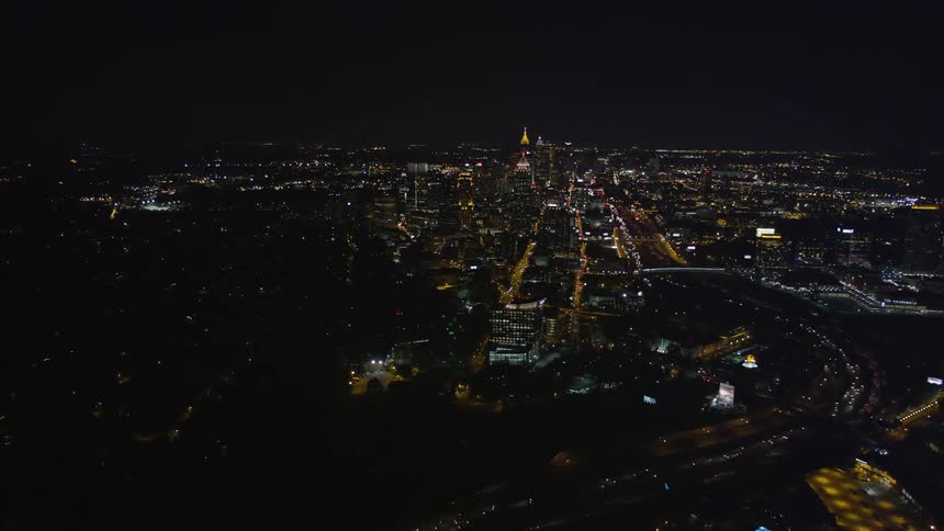 Aerial view of nighttime traffic flowing through the city center of Midtown Atlanta approaching from Buckhead Georgia