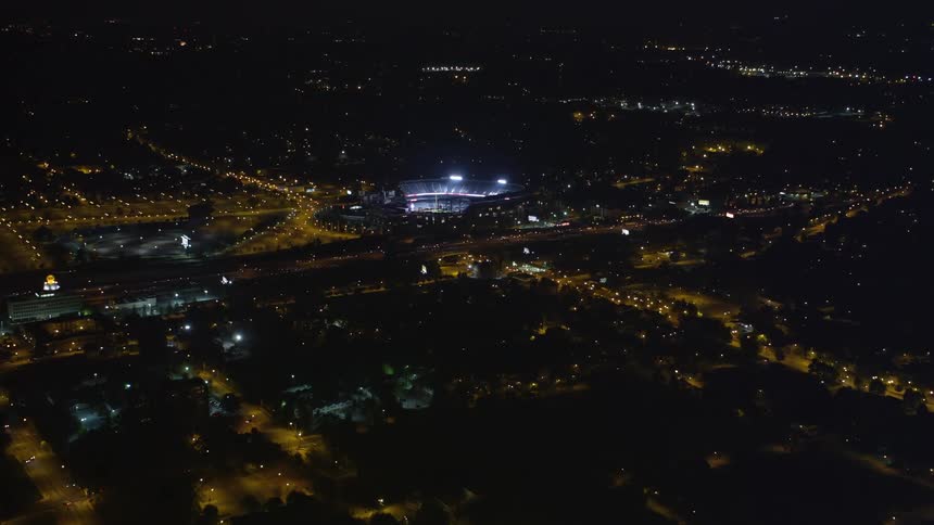 Aerial footage showing Turner Field in Atlanta Georgia at night with a birds eye view and a tilt downwards revealing the bright stadium lights and clear skies