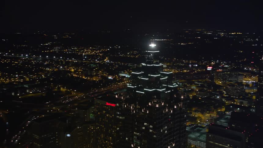Aerial footage orbiting SunTrust Plaza showcasing the vibrant night lights of downtown Atlantas towering skyscrapers