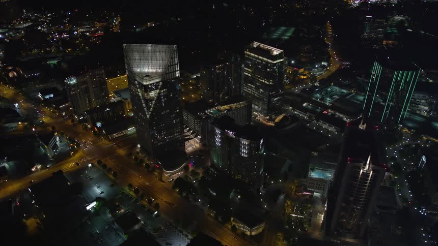 Aerial footage of Atlantas Buckhead district at night flying by skyscrapers towards Terminus Atlanta