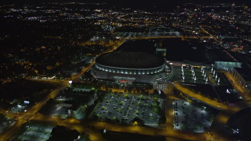 Approaching and orbiting the Georgia Dome this aerial footage captures the brightly lit football stadium in downtown Atlanta at night