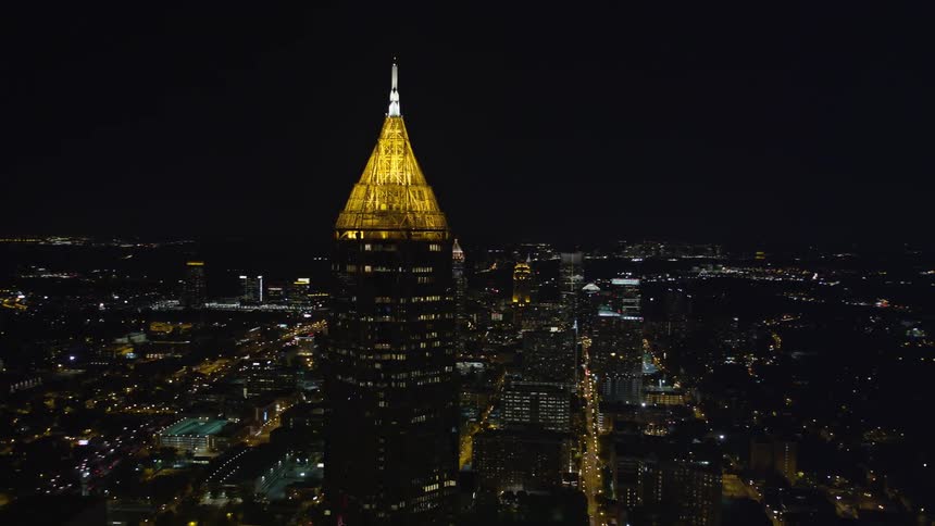 Aerial footage of Bank of America Plaza in Midtown Atlanta at night with a view of the moon and city skyline