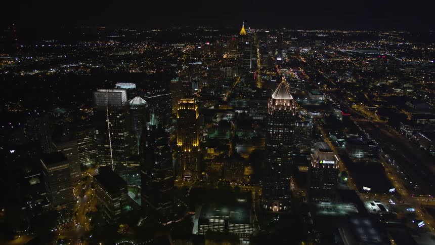 A breathtaking aerial view of Atlantas iconic skyscrapers including One Atlantic Center GLG Grand Promenade II and 1800 Peachtree as they are lit up during a stunning night skyline shot