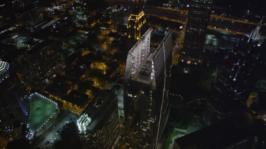 Aerial view of 1180 Peachtree and GLG Grand two high-rise modern buildings in Midtown Atlanta captured at night from a birds eye perspective