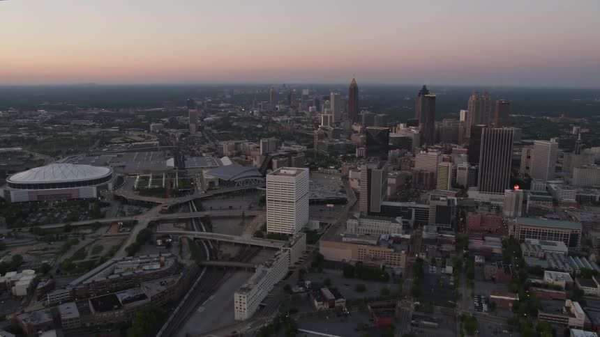 Approaching Downtown Atlanta at twilight aerial footage captures the Georgia Dome and Midtowns towering skyscrapers