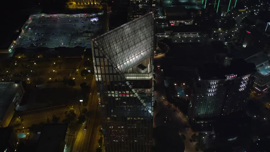 Approaching and orbiting around the mirrored glass high-rise of Terminus Atlanta Buckhead Georgia on a clear night