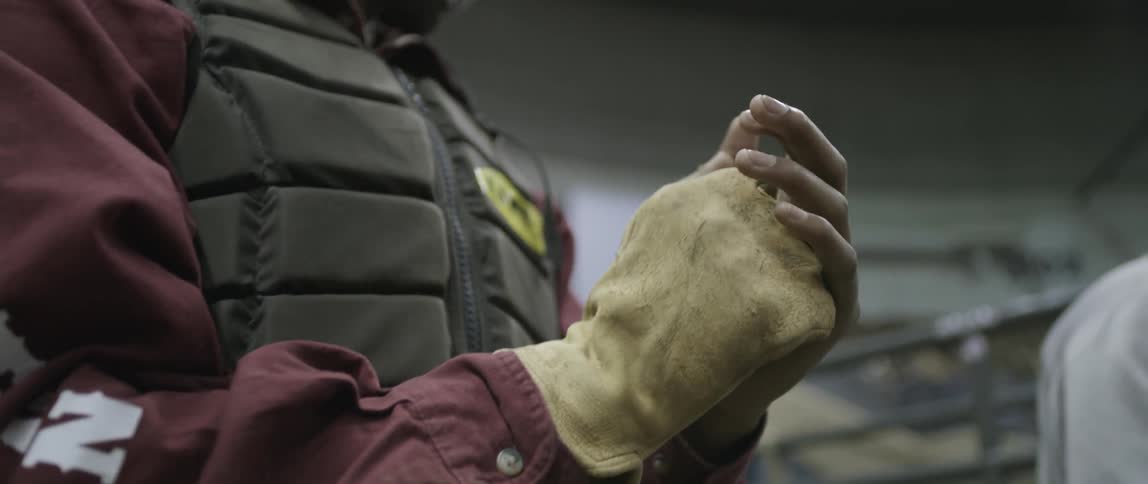 A person puts on a glove inside a building