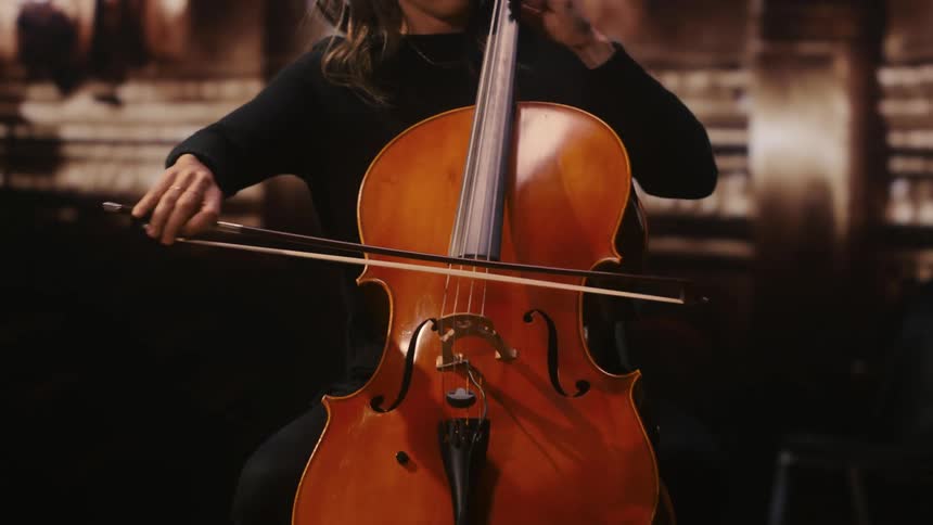 A woman plays the cello on stage