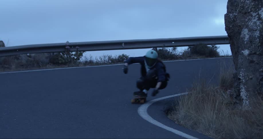 A person roller skates around a curve in the highway