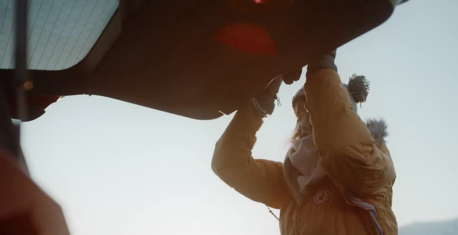 A woman closes the trunk to her sport utility vehicle