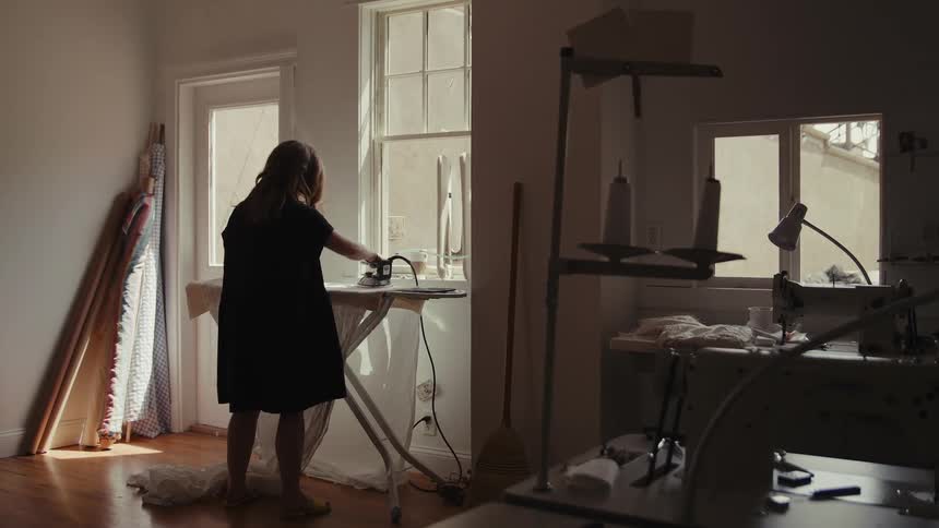 A tailor is ironing in the workplace