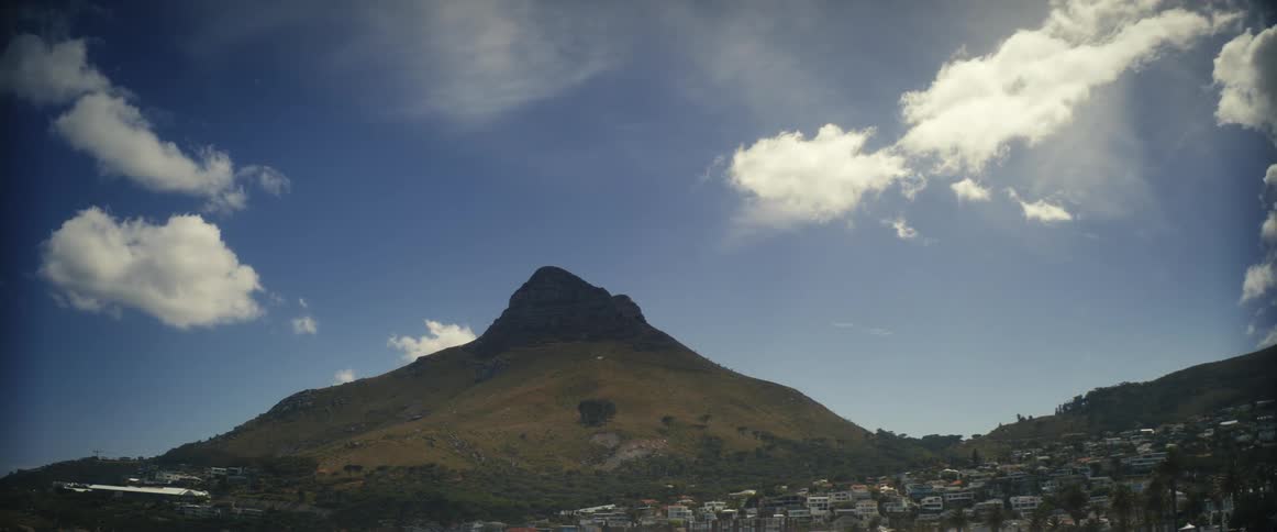Clouds flow over the town near the mountain