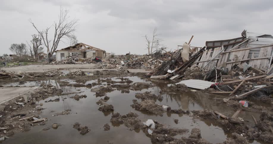 Houses are destroyed with a large pond of water in front