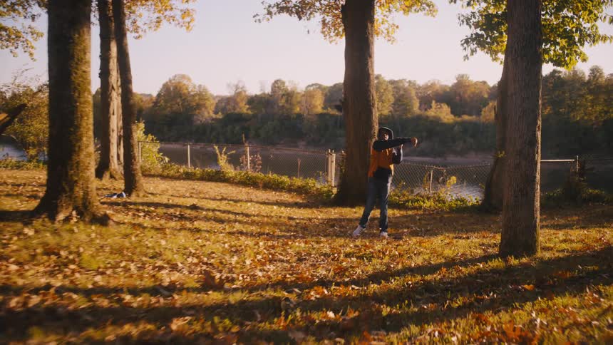 A family throwing around a football near trees with autum foliage