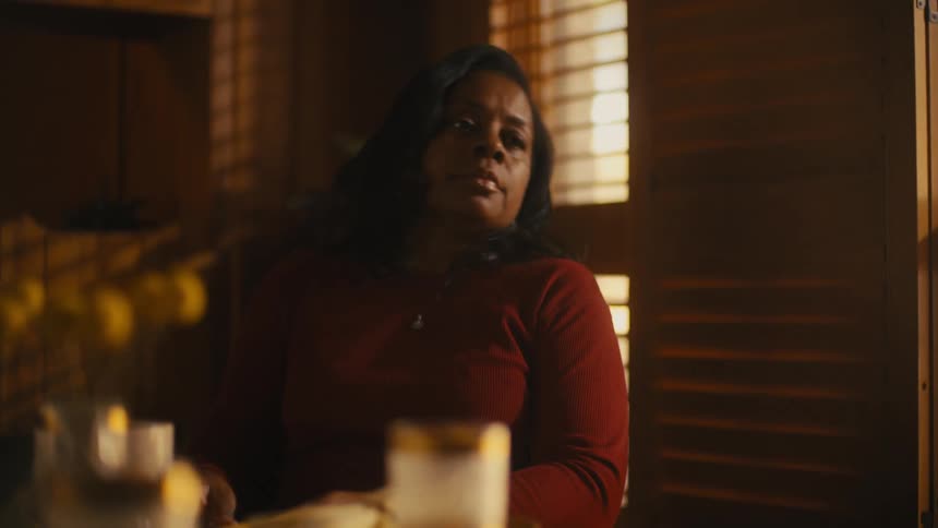 A woman is sitting down in a chair and is on her phone