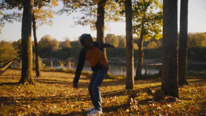A family throwing around a football in their backyard on an autumn day