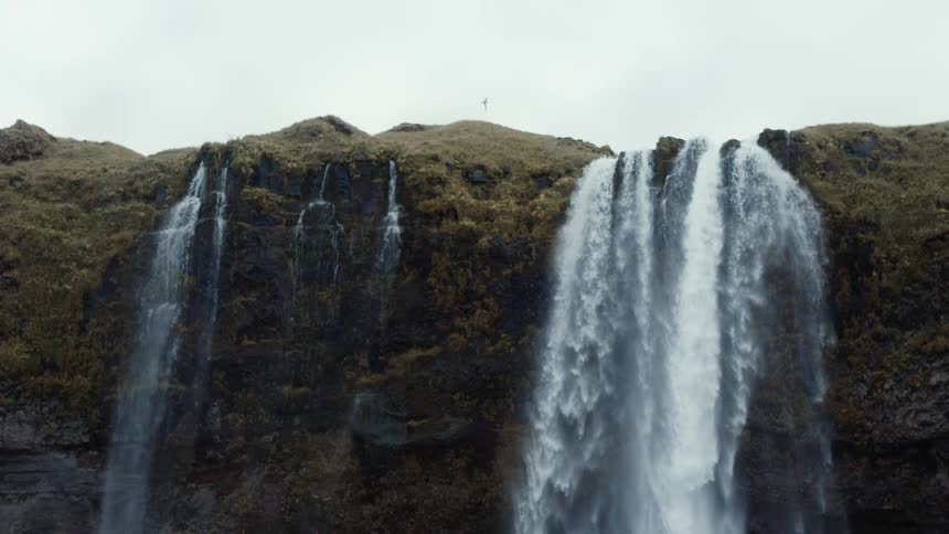 A waterfall gushing over a cliffside in nature