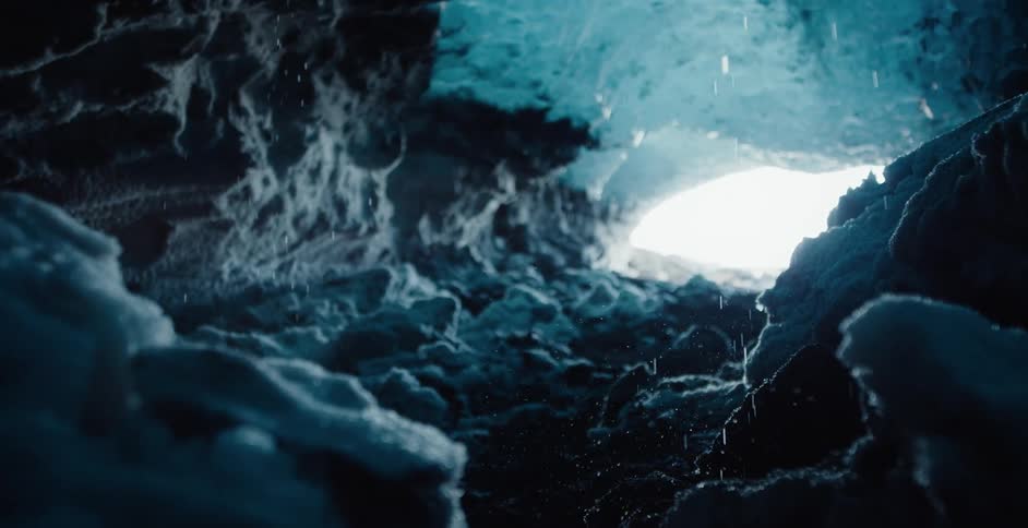 The view is of a cave and inside the cave it is snowing
