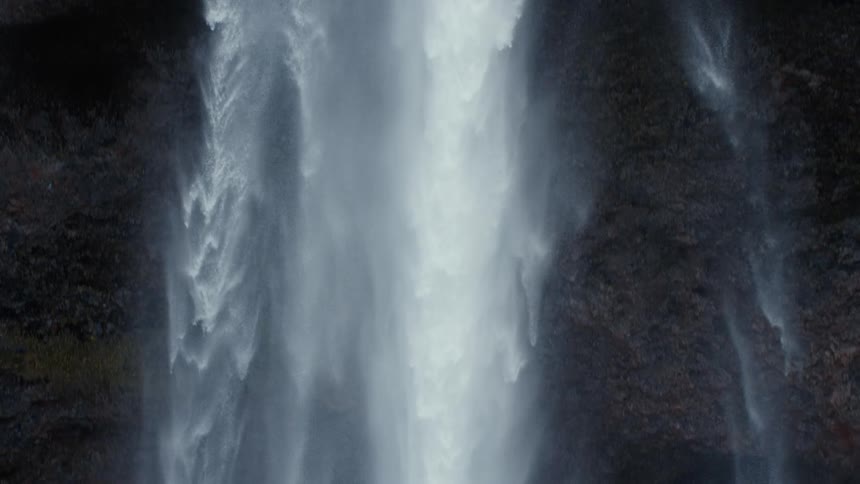 A waterfall gushing over a cliffside in nature