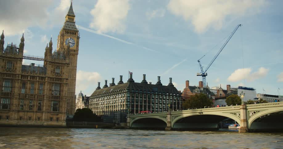 Pedestrians crowd bridge crossing the river thames to westminster and big ben